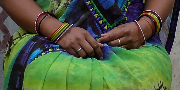 In this photograph taken on April 6, 2016, 'Meera' a victim of marital rape poses, sitting outside near her home in New Delhi.