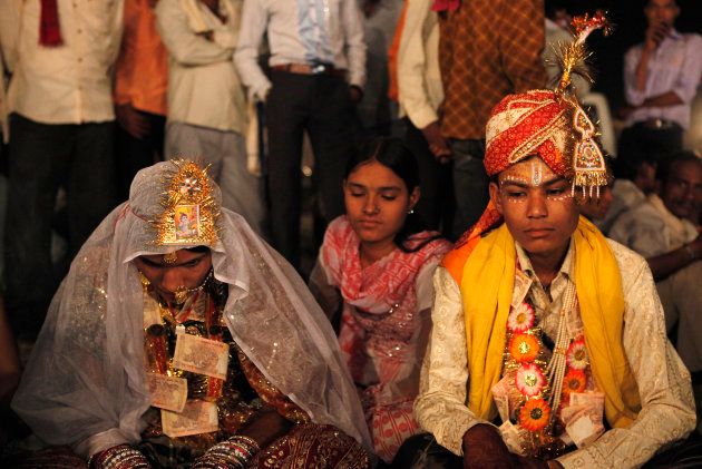 Hemant (R), 16, sits with his 13-year-old newly wed wife Saraswati in a mass marriage outside his village near Kota in the northwestern state of Rajasthan, May 17, 2010.
