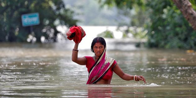 A woman wades through a flooded village in the eastern state of Bihar, India August 22, 2017. REUTERS/Cathal McNaughton TPX IMAGES OF THE DAY
