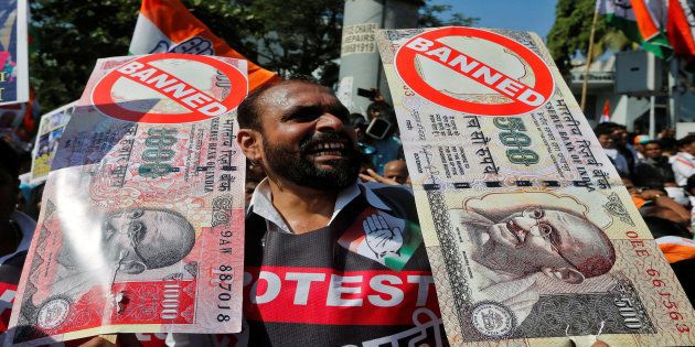A man holds placards and shouts slogans during a rally organized by India's main opposition Congress party against the government's decision to withdraw 500 and 1000 Indian rupee banknotes from circulation, in Mumbai, India November 28, 2016. REUTERS/Shailesh Andrade