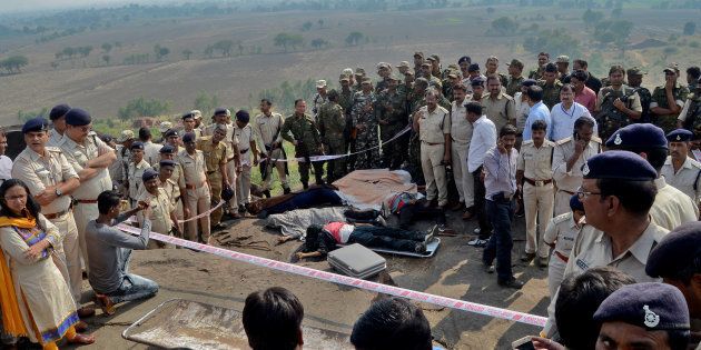 Police officers and Special Task Force soldiers stand beside dead bodies of the suspected members of the banned Students Islamic Movement of India (SIMI), who escaped a high security jail in Bhopal, and later got killed in an encounter at the Acharpura village on the outskirts of Bhopal, India, October 31, 2016.