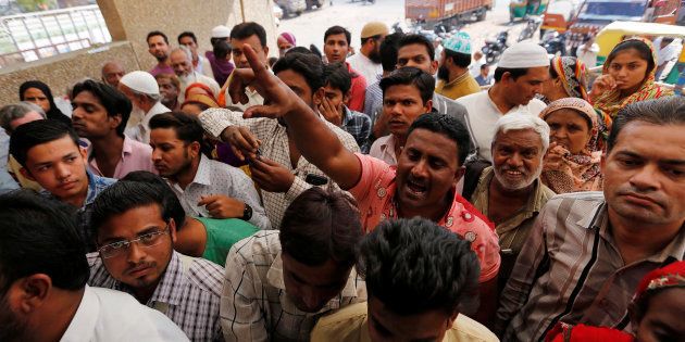 A man shouts at a bank manager urging him to open the bankâs gate amidst a crowd waiting to deposit or exchange their old high denomination banknotes outside a bank in Ahmedabad, India, November 24. 2016. REUTERS/Amit Dave