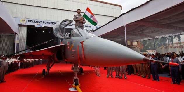 A Hindustan Aeronautics Limited engineer hurls the Indian flag as he stands in the cockpit of India's first indigenous naval Light Combat Aircraft LCA (Navy) NP1 during its roll out ceremony in Bangalore, India, Tuesday, July 6, 2010. The LCA (Navy) NP1 is capable of operation from an aircraft carrier and is now ready to undergo the phase of systems integration tests leading to ground runs, taxi trials and flight. (AP Photo/Aijaz Rahi)