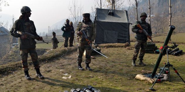 Indian army soldiers prepare to fire mortar shells towards hiding suspected militants in the Maniga area of Kupwara district north of Srinagar on November 23, 2015. A suspected rebel was killed at Maniga, near the frontier town of Kupwara in the north of the Himalayan territory, during an army search of the forested area. AFP PHOTO / AFP / STR (Photo credit should read STR/AFP/Getty Images)