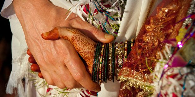 Indian wedding couple holding hands