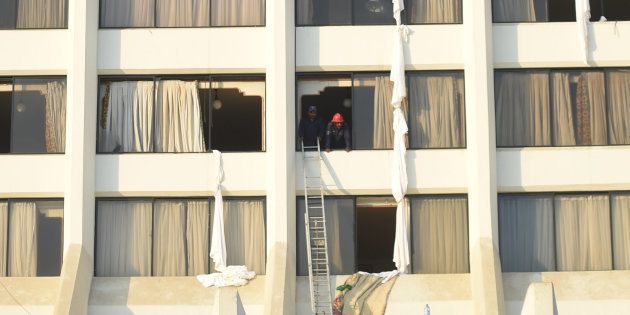 Pakistani fire fighters look from a room of Regent Plaza Hotel following a fire in the Pakistan's port city of Karachi on 5 December, 2016.
