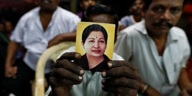 A supporter of Tamil Nadu Chief Minister J Jayalalithaa holds her photo. REUTERS/Danish Siddiqui
