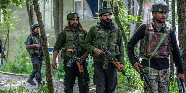 SAIMOH, KASHMIR, INDIA - MAY 27: Indian army troopers guard the area where top rebel commander of Hizbul Mujahideen Sabzar Ahmed , along with his associates Faizan Muzaffar, was taking refuge during a gun battle between Indian government forces and Kashmiri rebels on May 27, 2017 in Saimoh 45 km (28 miles) south of Srinagar, the summer capital of Indian administered Kashmir, India.