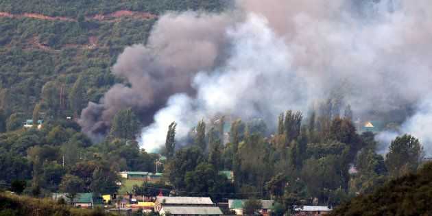 Smoke rises from the army base which was attacked by militants in the town of Uri, Kashmir on 18 September.