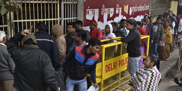 People queue up in front of Punjab National Bank to withdraw or deposit the money at Trilok Puri.