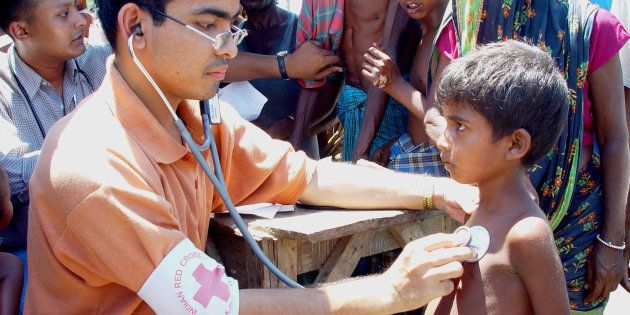 An Indian Red Cross doctor attends to a patient on the river islandTupka Chaar in the northeastern Indian state of Assam July 24, 2003.