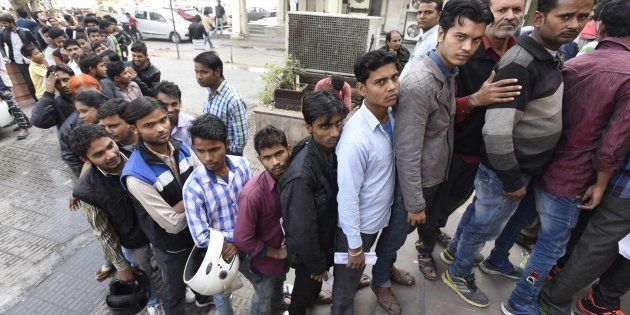 People stand in a queue outside banks to deposit and exchange old denomination Indian rupee 500 and 1000 currency notes, at Barakhamba Road, on November 24, 2016 in New Delhi, India.