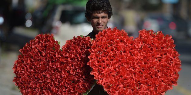 A Pakistani vendor carries heart-shaped bouquets for sale ahead of Valentine's Day along a street in Islamabad on February 13, 2017.