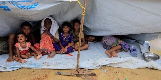 Rohingya refugees who crossed the border from Myanmar this week sit outside a school used as a shelter at Kotupalang refugee camp near Cox's Bazar, Bangladesh October 20, 2017. REUTERS/ Zohra Bensemra
