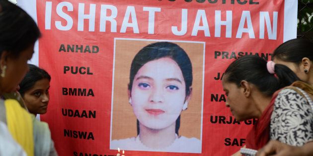 Supporters hold candles in front of a banner bearing the portrait of Ishrat Jahan during a protest in Ahmedabad on July 6, 2013.