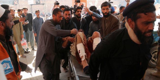 Hospital workers transport a man injured in the Charsadda blast to the hospital in Peshawar, Pakistan February 21, 2017.