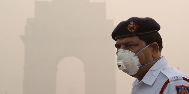 This photo taken on November 9, 2017 shows an Indian policeman wearing a protection mask as he works near India Gate amid heavy smog in New Delhi.