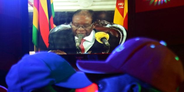 People watch as Zimbabwean President Robert Mugabe addresses the nation on television, at a bar in Harare, Zimbabwe, November 19, 2017. REUTERS/Philimon Bulawayo