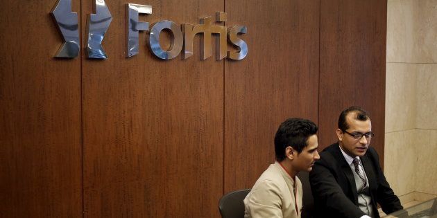 Employees sit on the helpdesk reception of the Fortis Memorial Hospital at Gurgaon.
