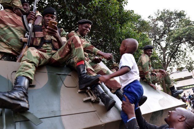 People celebrate with Zimbabwe Defence Force soldiers in the streets of Harare, after the resignation of Zimbabwe's president Robert Mugabe on November 21, 2017.