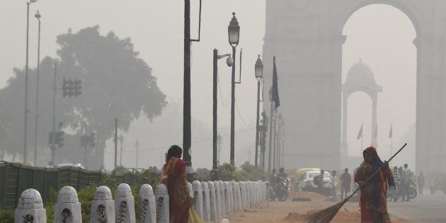 A sweeper cleans a road amid heavy smog near India Gate in New Delhi on November 16, 2017.