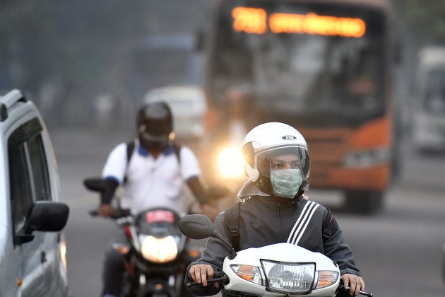 A motorcyclist wears a surgical mask on the streets of New Delhi.