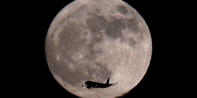 A passenger plane, with a 'supermoon' full moon seen behind, makes its final landing approach towards Heathrow Airport in London, Britain, January 1, 2018.
