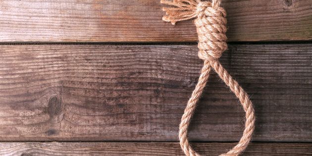 rope knotted in noose on wooden background