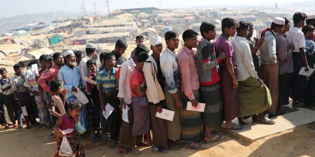 Rohingya refugees stand in a queue to collect aid supplies in Kutupalong refugee camp in Cox's Bazar, Bangladesh, January 21, 2018.