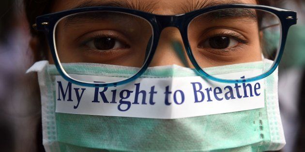 TOPSHOT - An Indian youth wearing a pollution mask participates in a march to raise awareness of air pollution levels in New Delhi on November 15, 2017.