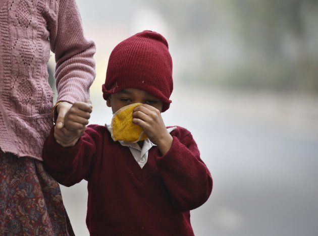 NEW DELHI, INDIA - DECEMBER 4: A child taking precautions against cold weather and smog at Green Park, on December 4, 2017 in New Delhi, India. Air quality remained very poor with air quality index at 320, which agencies consider unfit for inhalation even by healthy people. The minimum temperature was recorded at 10 degree Celsius and maximum was recorded at 23 degree Celsius. Smog thickened in the evening as number of vehicles increased on the roads when people rushed home. (Photo by Sanchit Khanna/Hindustan Times via Getty Images)