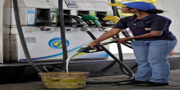 A worker fills a bucket with diesel at a gas station in the eastern Indian city of Siliguri.