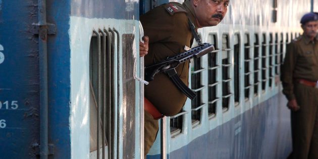 A Railway Police personnel peeps out from the door of a special passenger train at a railway station in Chandigarh.