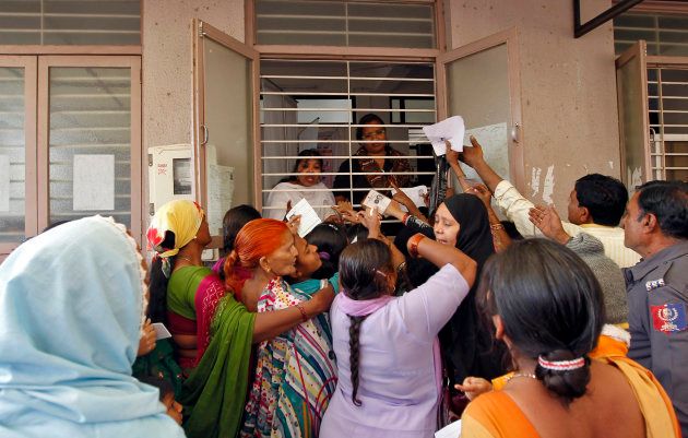 Woman jostle to enrol themselves for Unique Identification (UID) database system in the outskirts of the western Indian city of Ahmedabad February 14, 2013.