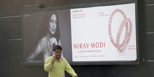 A man talks on a phone as he walks past a Nirav Modi showroom during a raid by the Enforcement Directorate, a government agency that fights financial crime, in New Delhi, India, February 15, 2018. REUTERS/Adnan Abidi