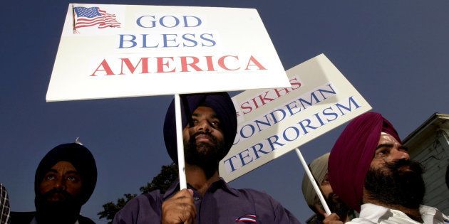 Sikh men carry patriotic placards at a community service to remember victims of terrorist attacks, October 10, 2001 in Santa Ana, CA.