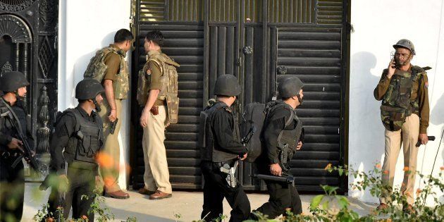 Uttar Pradesh Anti Terror Squad members take positions near a building where a suspected terrorist was holed up in the Thakurganj area of Lucknow on Tuesday evening.