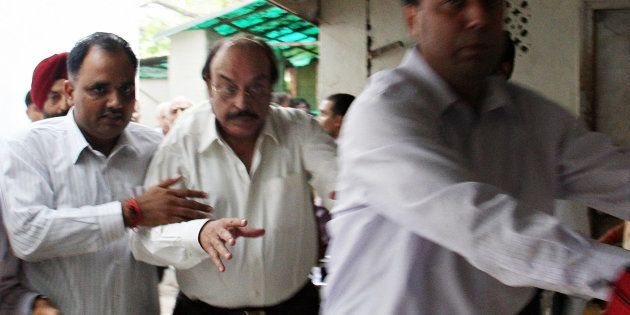 Indian real estate businessman businessman Gopal Ansal (C) is escorted to the prison at the Patiala House Court in New Delhi on September 11, 2008.