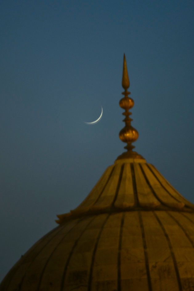 A view of crescent moon near a Jama Masjid Minaret on the eve of Eid al-fitr.