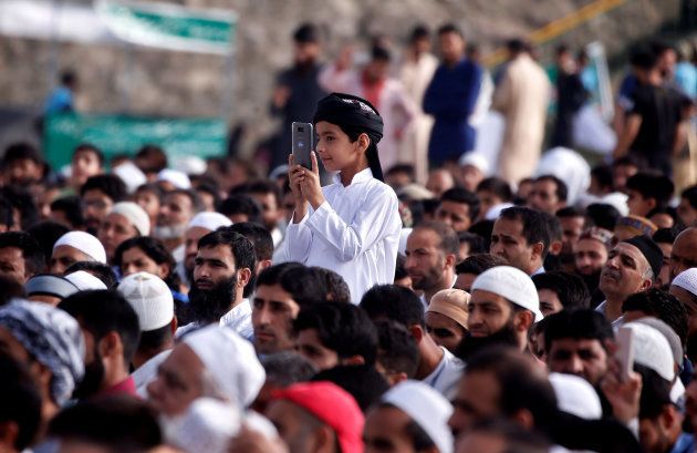 A boy takes a picture prayers in Srinagar.
