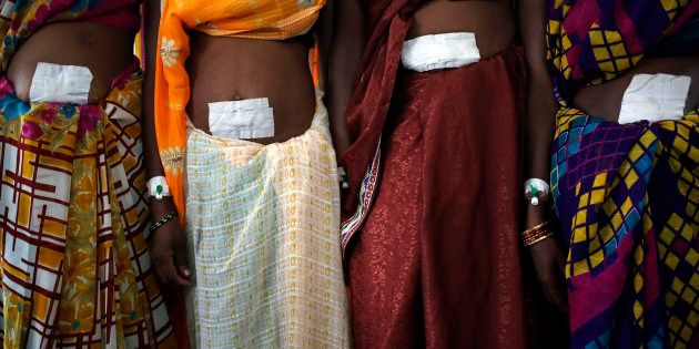 Women, who underwent sterilization surgery at a government mass sterilisation camp, pose for pictures inside a hospital at Bilaspur district in the eastern Indian state of Chhattisgarh November 14, 2014.