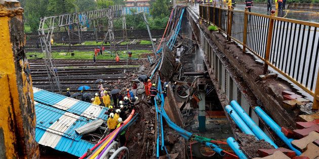 Rescue workers seen working at the site of an overbridge that collapsed over the railway tracks after heavy rains in Mumbai.