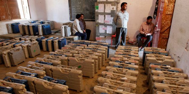 Members of the election staff sit in a room filled with electronic voting machines (EVM) at a distribution centre on the eve of the fourth phase of state assembly election in Allahabad, India, February 22, 2017.
