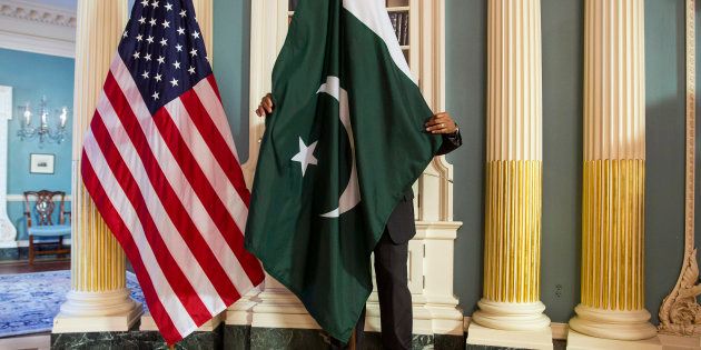 A State Department contractor adjust a Pakistan national flag before a meeting between U.S. Secretary of State John Kerry and Pakistan's Interior Minister Chaudhry Nisar Ali Khan on the sidelines of the White House Summit on Countering Violent Extremism at the State Department in Washington February 19, 2015. REUTERS/Joshua Roberts (UNITED STATES - Tags: POLITICS)