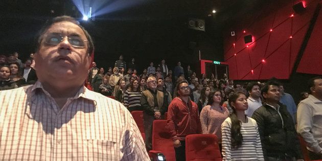 Audience members stand for the Indian national anthem before a movie starts at a cinema in New Delhi.