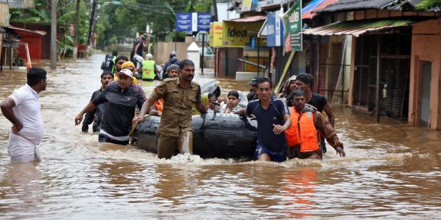 Rescuers evacuate people from a flooded area to a safer place in Aluva in Kerala on Saturday.
