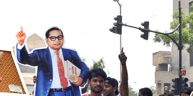 NEW DELHI, INDIA - MAY 20: A protestor carries a giant cut-out of Dr. BR Ambedkar during a protest by the members of dalit and tribal community against atrocities demanding for justice at Parliament Street, on May 20, 2018 in New Delhi, India. (Photo by Sushil Kumar/Hindustan Times via Getty Images)