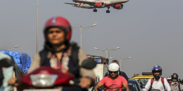 An Air India Ltd. aircraft passes over traffic as it prepares to land at Chhatrapati Shivaji International Airport in Mumbai, India, on Monday, Nov. 7, 2016.