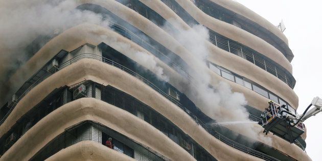 Residents wait to be rescued as firefighters try to extinguish a fire at a residential building in Mumbai, India August 22, 2018. REUTERS/Francis Mascarenhas