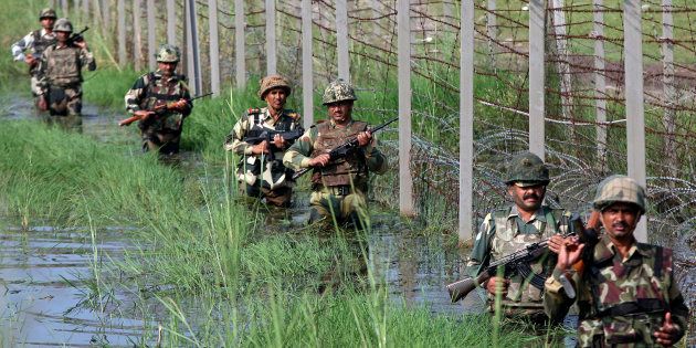 Indian Border Security Force (BSF) soldiers patrol the fenced border with Pakistan.